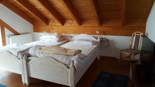 a white bed in a room with a wooden ceiling at BB dänisch/deutsch in Cologne