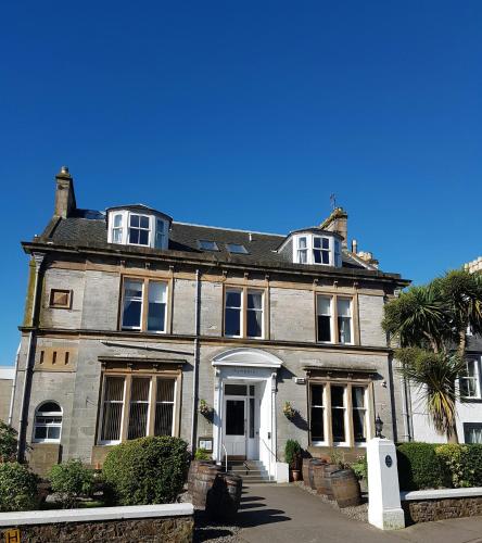 an old house with a palm tree in front of it at Ardshiel Hotel in Campbeltown