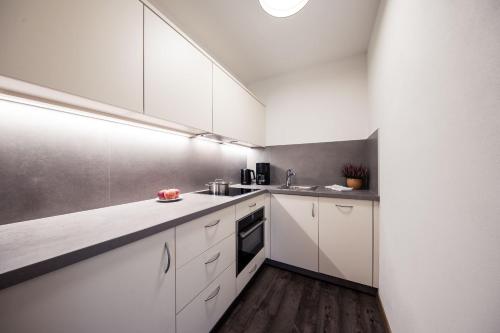 a kitchen with white cabinets and a sink at Residence Panorama Pfelders in Pfelders