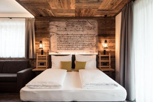 1 dormitorio con 1 cama grande y pared de madera en Residence Panorama, en Pfelders