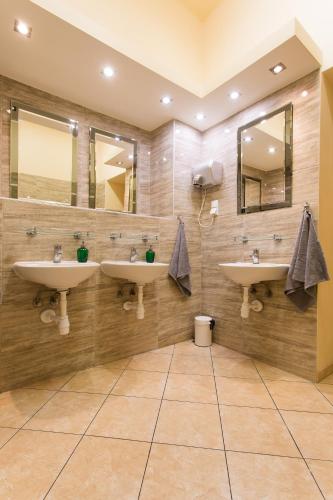a bathroom with two sinks and two mirrors at Moon Hostel Warszawa in Warsaw