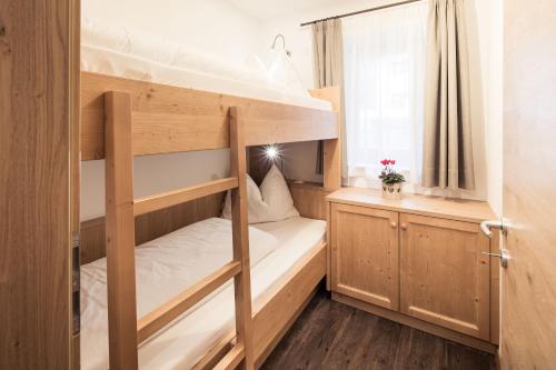 a small room with two bunk beds and a window at Residence Panorama Pfelders in Pfelders