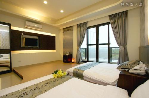 a hotel room with two beds and a television at Lambo Stay Inn in Toucheng