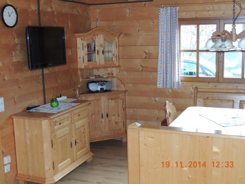 a kitchen with wooden walls and a tv in a cabin at Egghartguthütte in Tauplitz