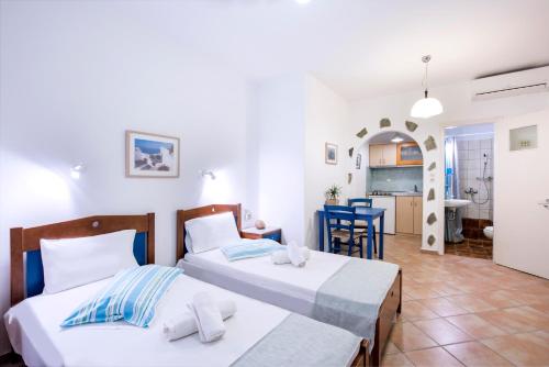 a bedroom with two beds and a living room at Erisimo in Aegiali