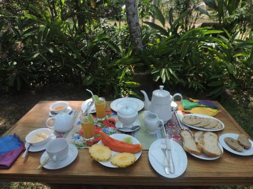 a wooden table with breakfast foods and drinks on it at Silva Rest in Unawatuna