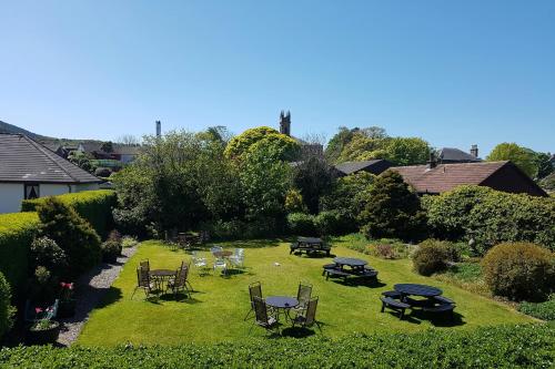 a garden with tables and chairs on the grass at Ardshiel Hotel in Campbeltown
