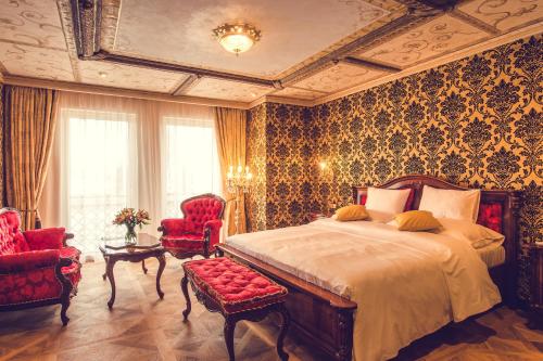 Hotel Florian Palace في جينديتشوف هراديك: غرفة نوم بسرير كبير وكرسيين