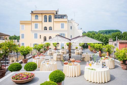 a banquet hall with tables and umbrellas in front of a building at Hotel Ponte Sisto in Rome