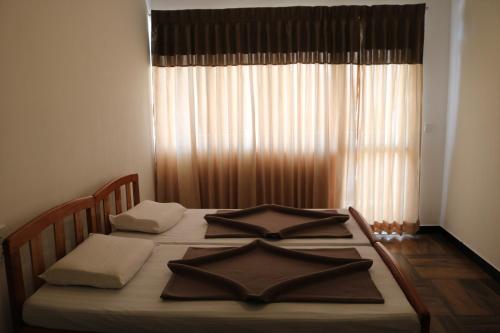 a bedroom with a large bed with a window at Queens rest inn in Haputale