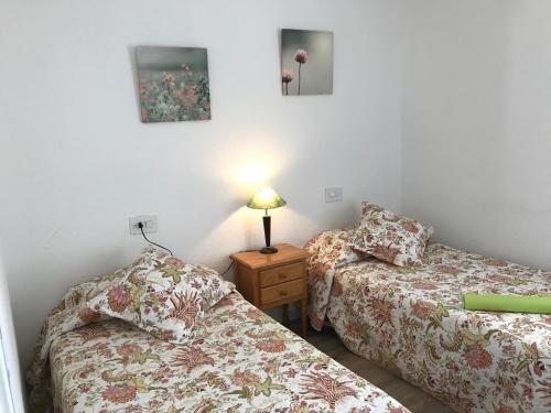 dwa łóżka w pokoju z lampką na stole w obiekcie mar y golf en muchavista w Alicante