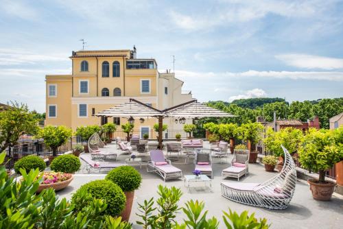 un patio con sedie e ombrelloni di fronte a un edificio di Hotel Ponte Sisto a Roma