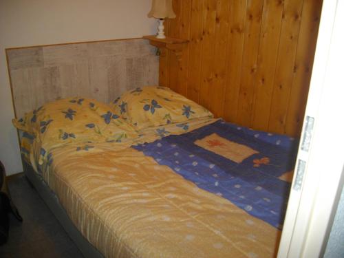 a bed in a bedroom with a wooden headboard at Les Cretets in Les Rousses