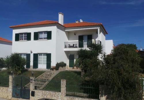 a white house with a fence in front of it at Villa Terra Da Eira in Mafra