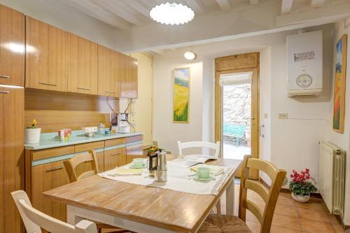 - une cuisine avec une table et des chaises en bois dans la chambre dans l'établissement Arts and Flowers, à Sinalunga