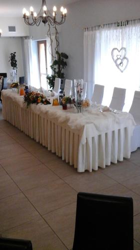 una mesa larga con manteles blancos. en Karczma Dolina Pstrąga, en Machowa