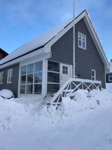 a house with snow in front of it at Hotel Nuuk - Apartment Nanoq in Nuuk