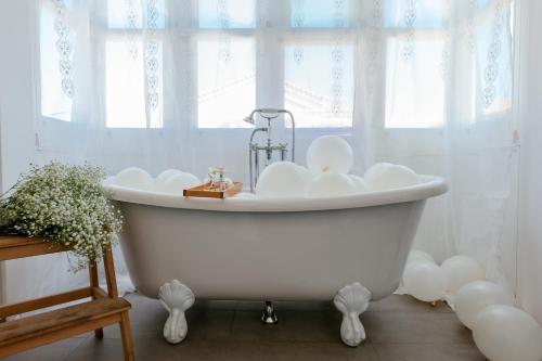 baño con bañera blanca y ventana en Alaçatı Casa Bella +12, en Alacati