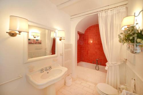 bagno bianco con lavandino e servizi igienici di La Terrazza a Capri