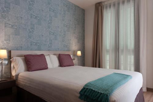 um quarto com uma cama grande e uma janela em MH Apartments S. Familia em Barcelona