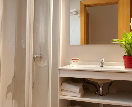 a bathroom with a sink and a mirror at MH Apartments S. Familia in Barcelona