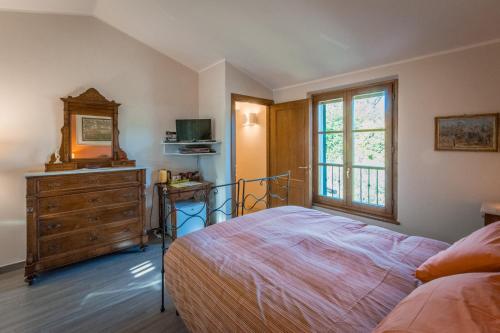 a bedroom with a bed and a dresser and a window at Il Podere di Giustina in Montecarlo