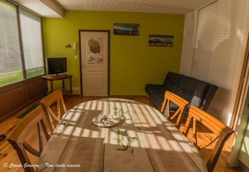 un salon avec une table et un canapé dans l'établissement Village de Nasbinals Aubrac Electro Vélo, à Nasbinals