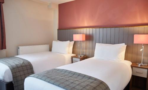 a hotel room with two beds and two lamps at Fishermans Tavern in Dundee