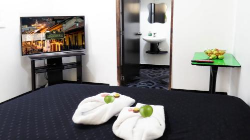 una habitación de hotel con toallas en una cama y TV en Hotel Bogota House, en Bogotá