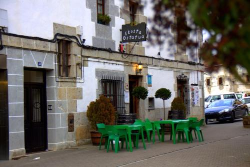 a group of green tables and chairs outside of a building at Hostal Rural Elosta in Lekunberri