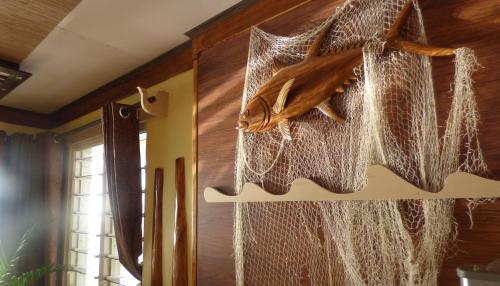 a fish hanging from a net in a room at Mouggae Blues Villas in Beau Vallon