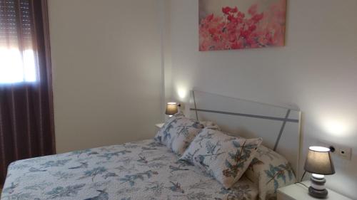 um quarto com uma cama com dois candeeiros em Residencial La Llosa em La Llosa