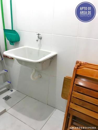a white sink in a bathroom with a wooden chair at Mar de Boipeba in Ilha de Boipeba