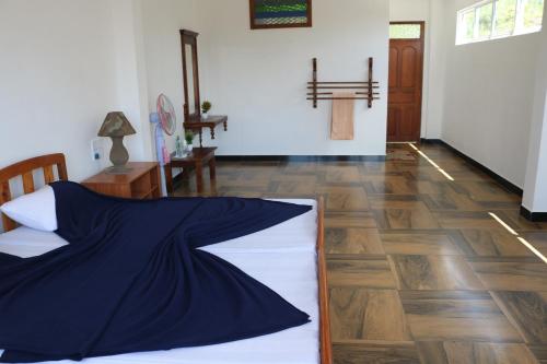 a bedroom with a bed and a cross on the wall at Queens rest inn in Haputale