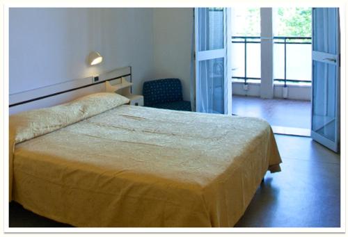 a hotel room with a bed and a chair at Hotel B&B Gladys in Cesenatico