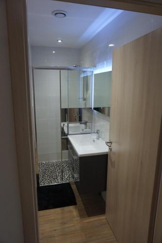 une salle de bain avec un lavabo blanc et un miroir dans l'établissement Les feignes cerfdoré, à La Bresse