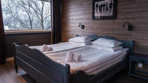 1 dormitorio con cama con almohadas y ventana en Skogstad Hotel, en Hemsedal