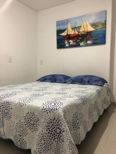 1 dormitorio con 1 cama con una pintura en la pared en Apartamento Rodadero VICO, en Santa Marta