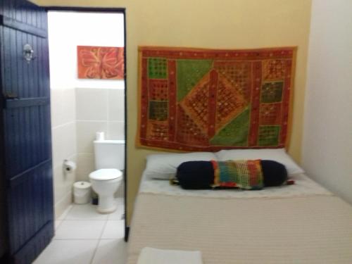 a small bathroom with a bed and a toilet at Casarão do Pontal in Coruripe