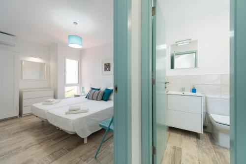 une chambre avec un lit et une salle de bain avec un lavabo dans l'établissement Bungalow tipo duplex en Sonneland, Maspalomas, à Maspalomas