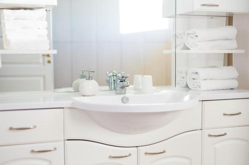 uma casa de banho branca com um lavatório e toalhas em Den Gamle Grænsekro Inn em Christiansfeld