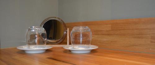 two glasses sitting on top of a wooden table at Le Clos Margot in Vertus