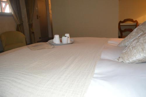a white bed with two cups on a tray on it at Le Clos Margot in Vertus