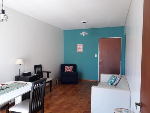 uma sala de estar com paredes azuis e uma mesa e cadeiras em Departamento Vicente Lopez sobre Av Maipu em Vicente López