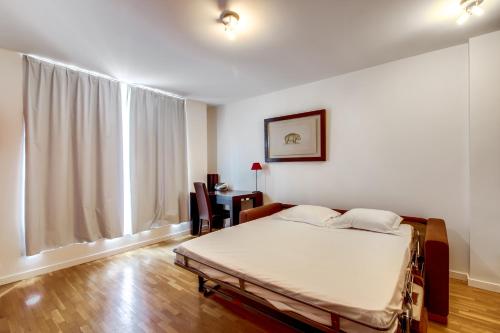 une chambre avec un lit et une grande fenêtre dans l'établissement Champs Elysées George V ID 306, à Paris