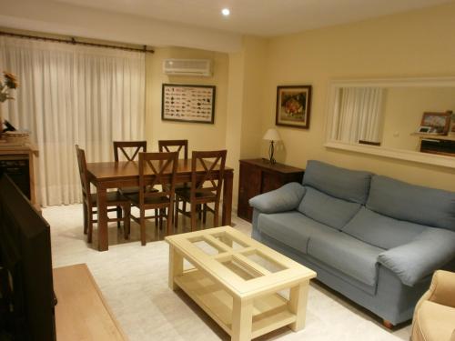 a living room with a blue couch and a table at Precioso Apartamento in Peñíscola