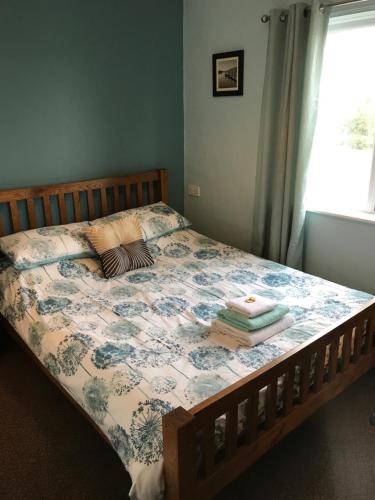 a bedroom with a bed with a floral comforter at The Lobster Pot in Marloes