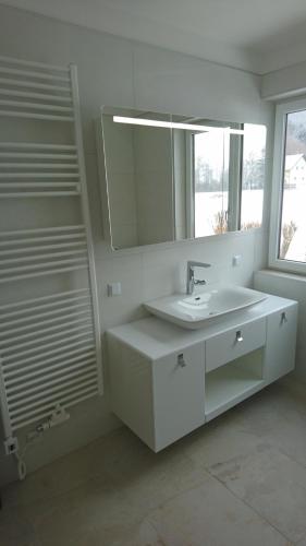 a white bathroom with a sink and a mirror at Haus Mup in Spittal an der Drau