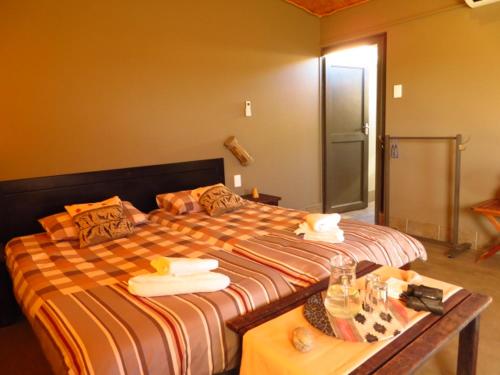 1 dormitorio con 1 cama grande y 1 mesa en Soft Adventure Camp, en Solitaire
