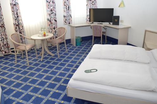 Zimmer mit einem Bett, einem Tisch und einem Schreibtisch in der Unterkunft Boardinghaus zu Coburg Residenz in Coburg